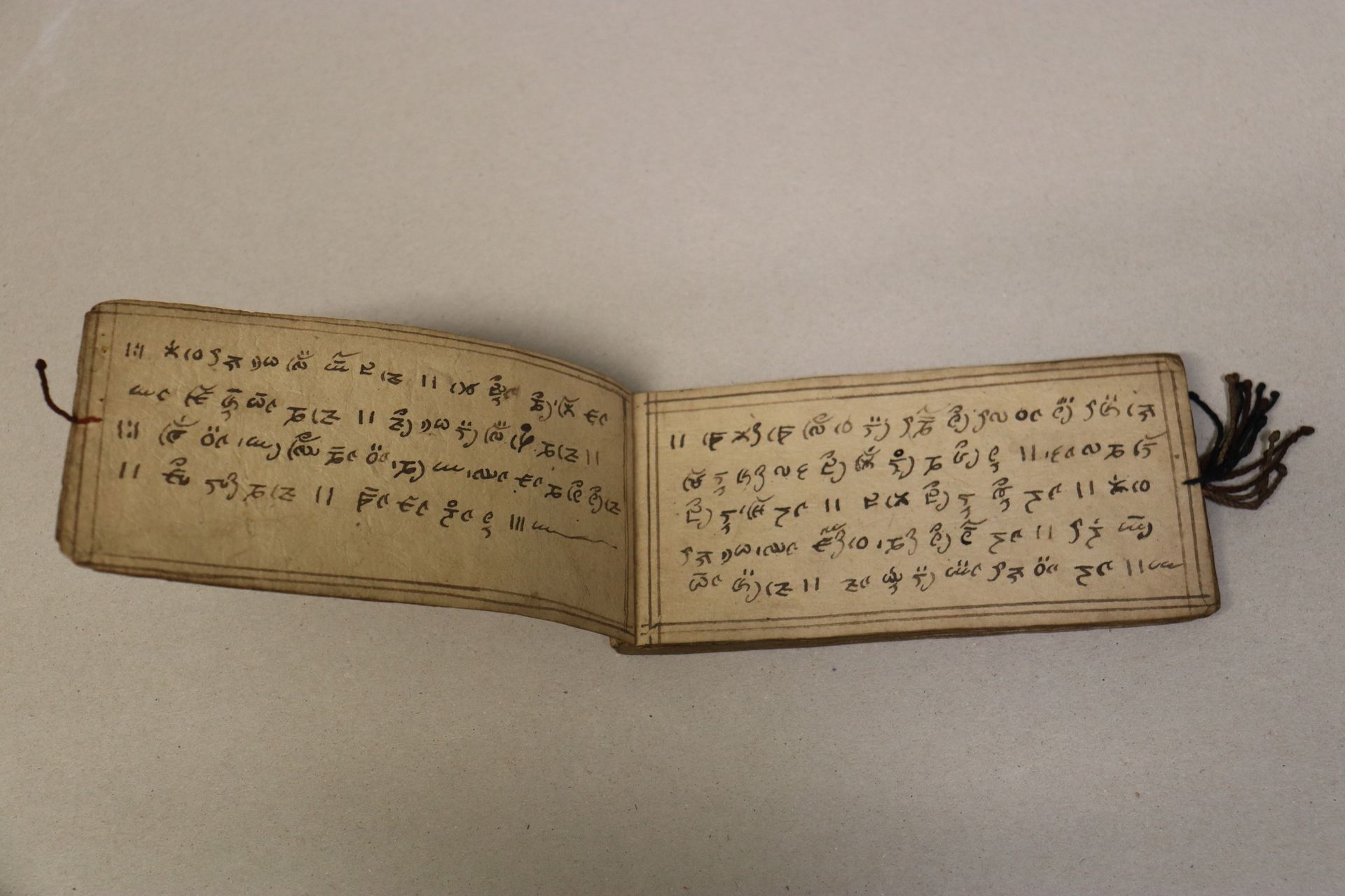 Livre de prières, papier, encre noire, cordelettes textiles, 19ème siècle, Asie du Sud, Tibet.