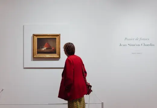 Une femme observe un tableau. 